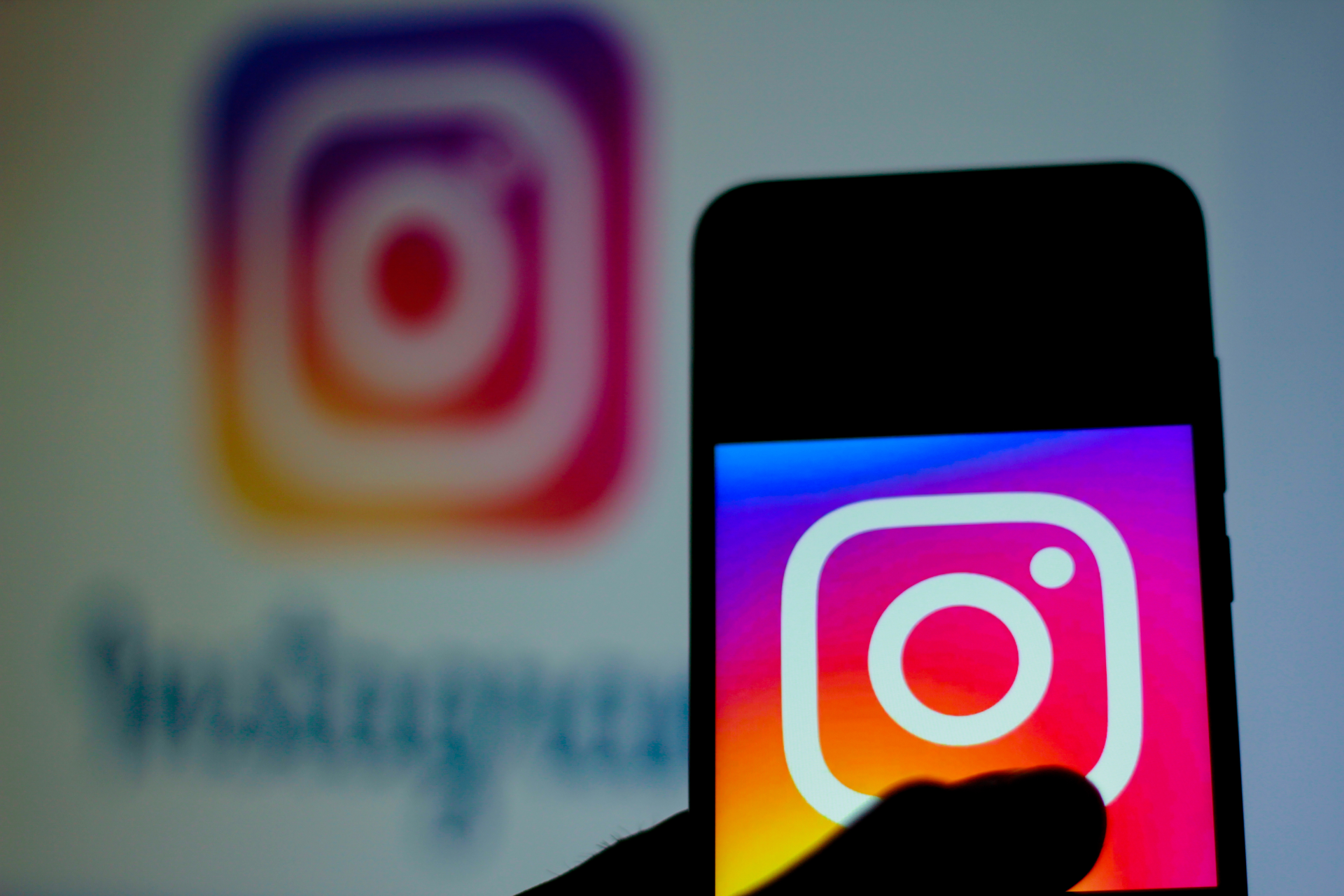 Person holding smartphone showing Instagram logo