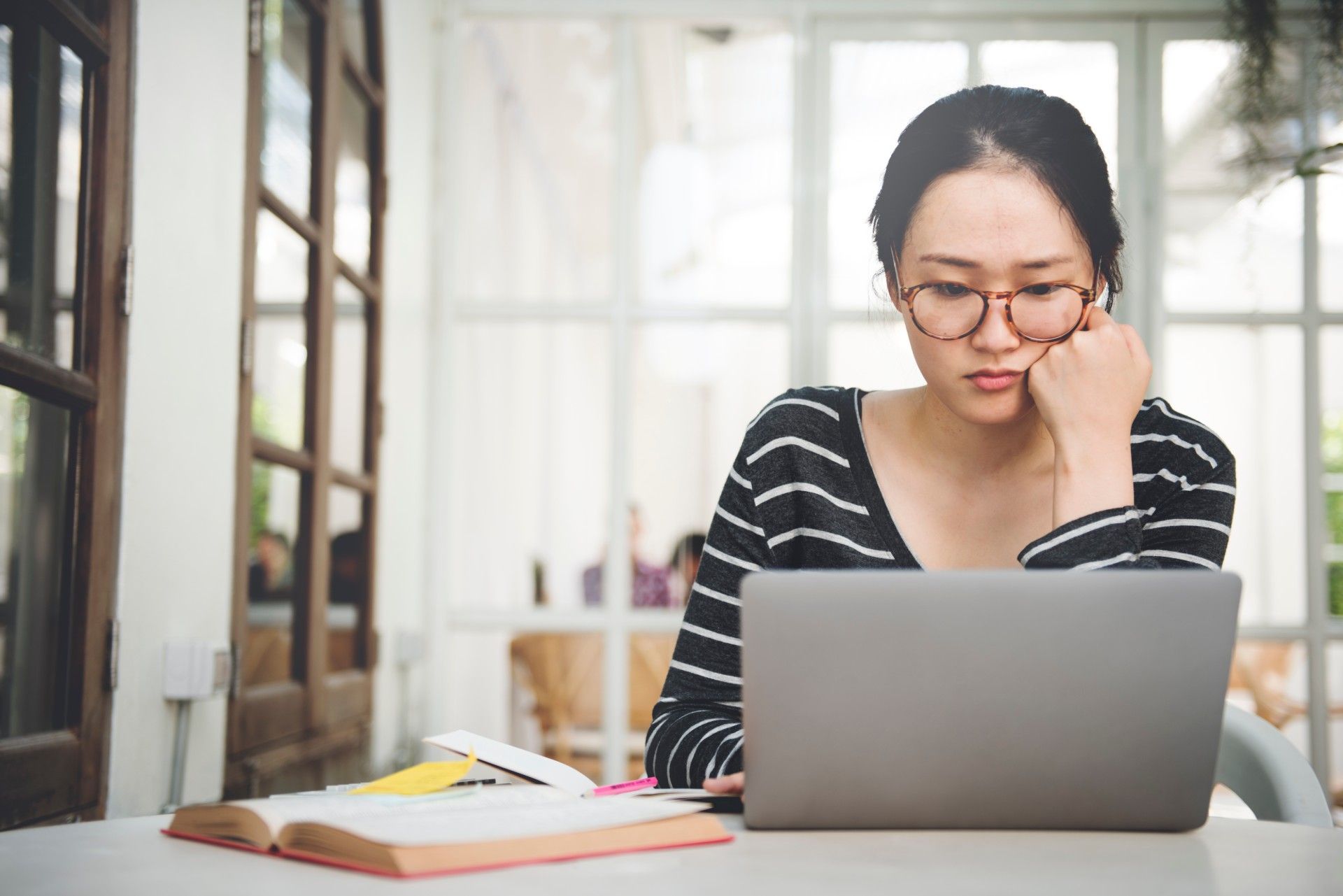 Woman studies using laptop and open book - bpp university
