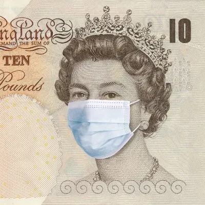 British ยฃ10 note with queen's face wearing surgical mask - coronavirus recession