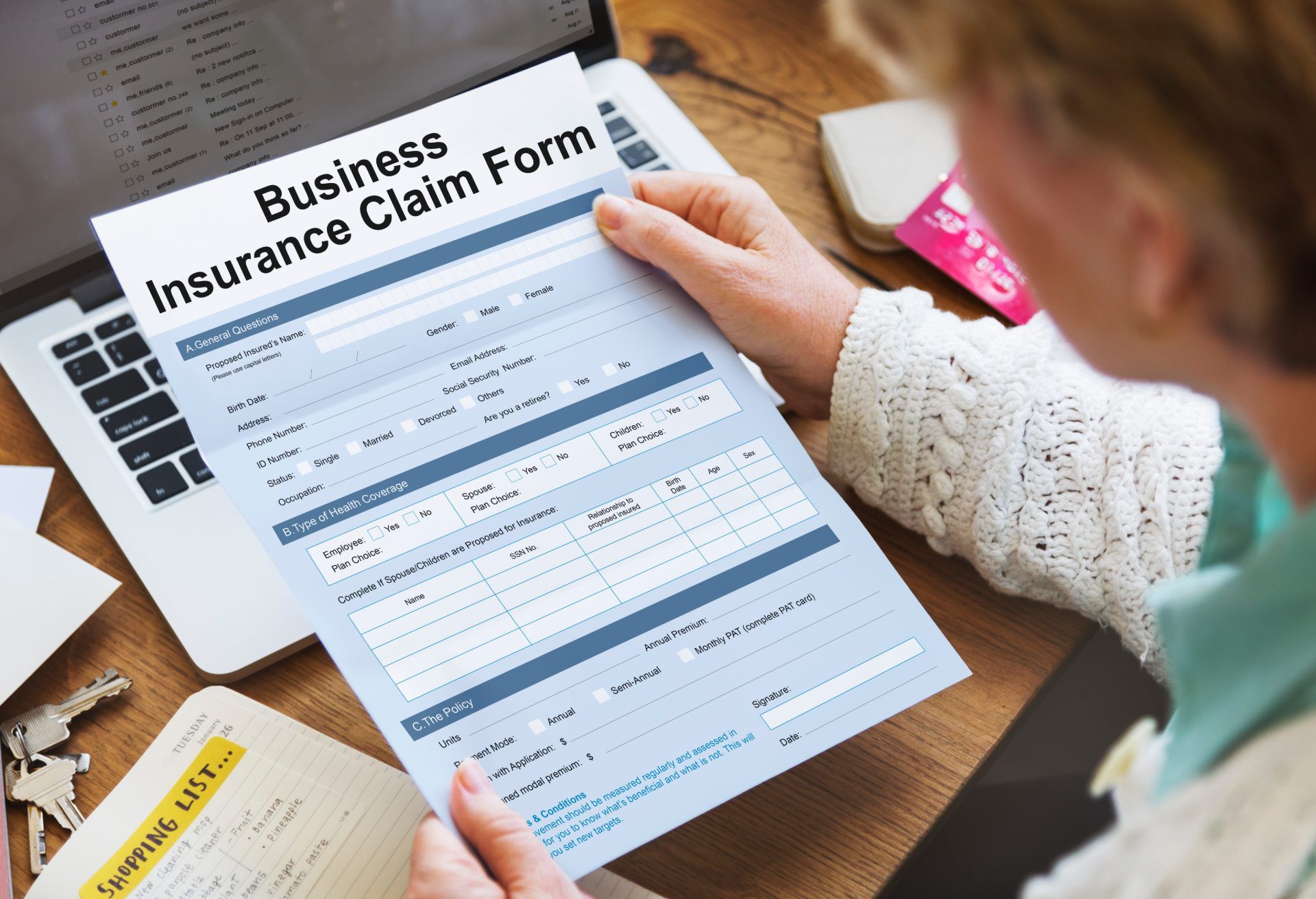 Woman sitting at desk holding business insurance claim form - test case