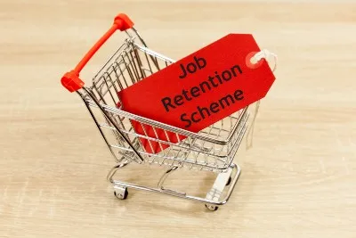 Small grocery cart carrying red tag that says "job retention scheme" - furlough scheme