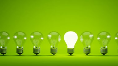 One in a row of lightbulbs is lit up against a green background - Bulb
