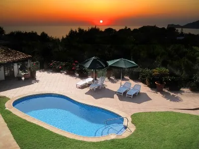 Pool in yard near body of water at sunset - Cottages.com