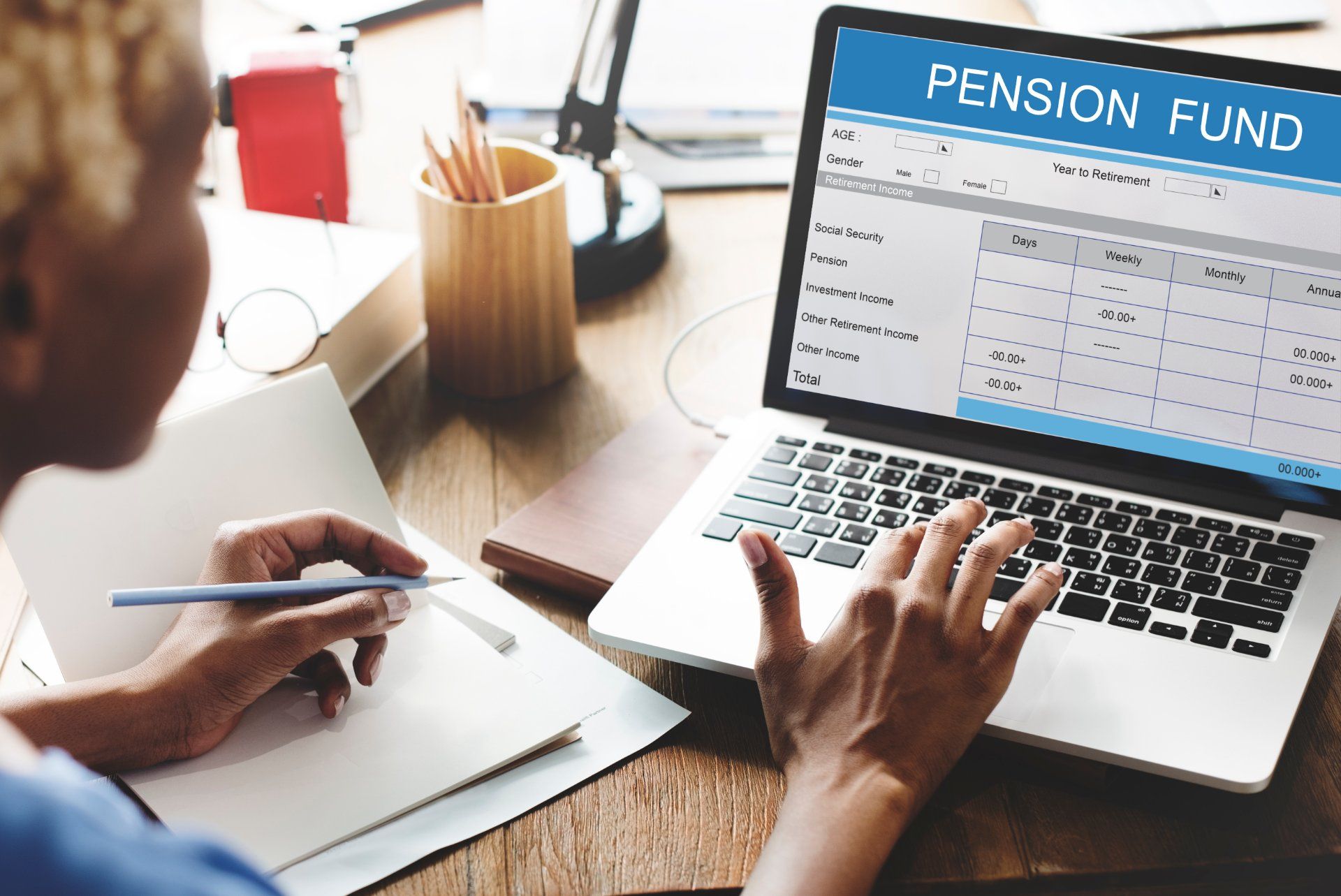 Woman works on pension fund page on laptop - Avacade