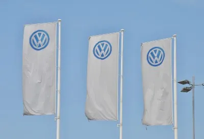VW logo flags fly outside Volkswagen dealership - Volkswagen emissions