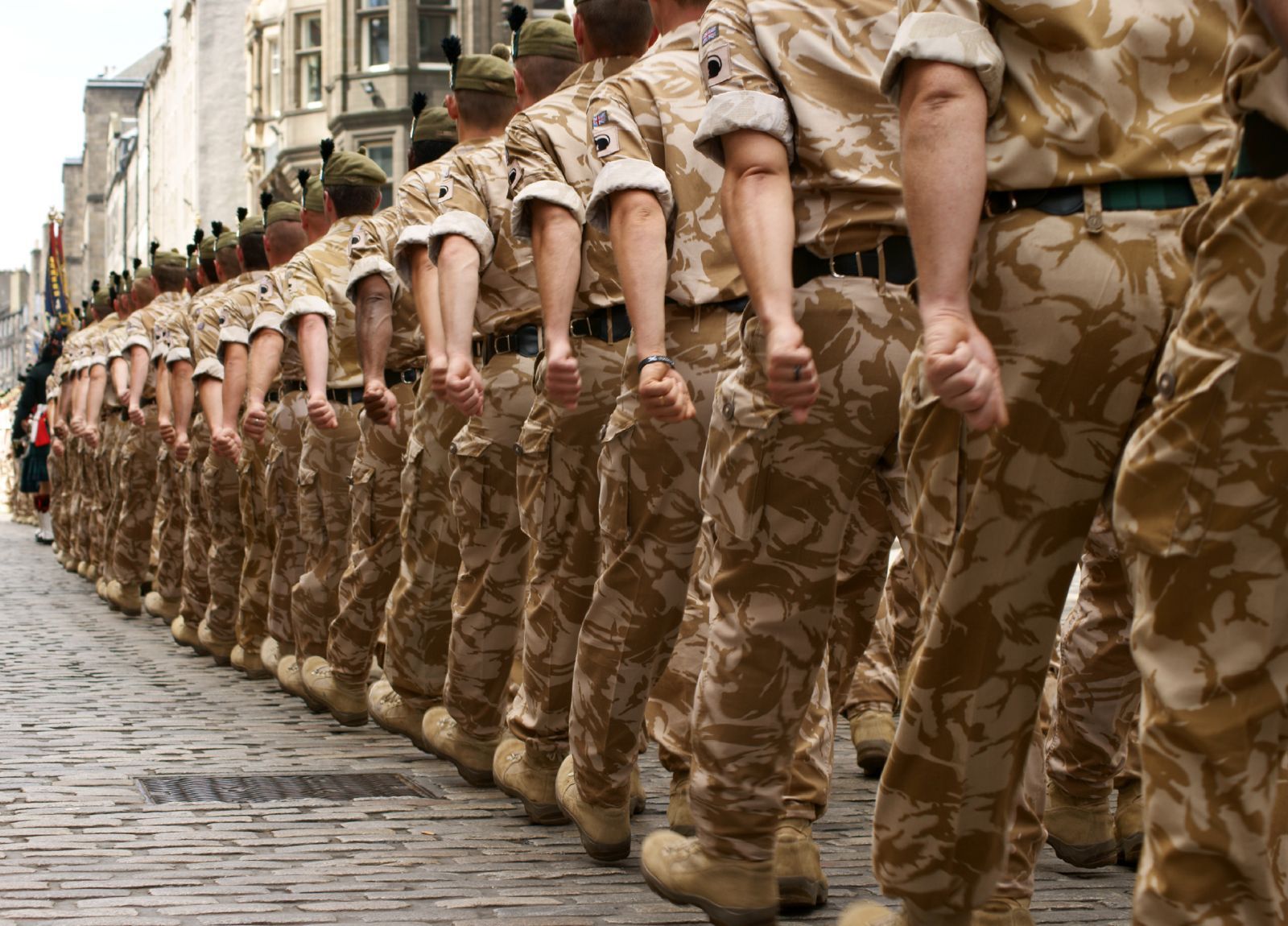 British troops march down a street - Lariam