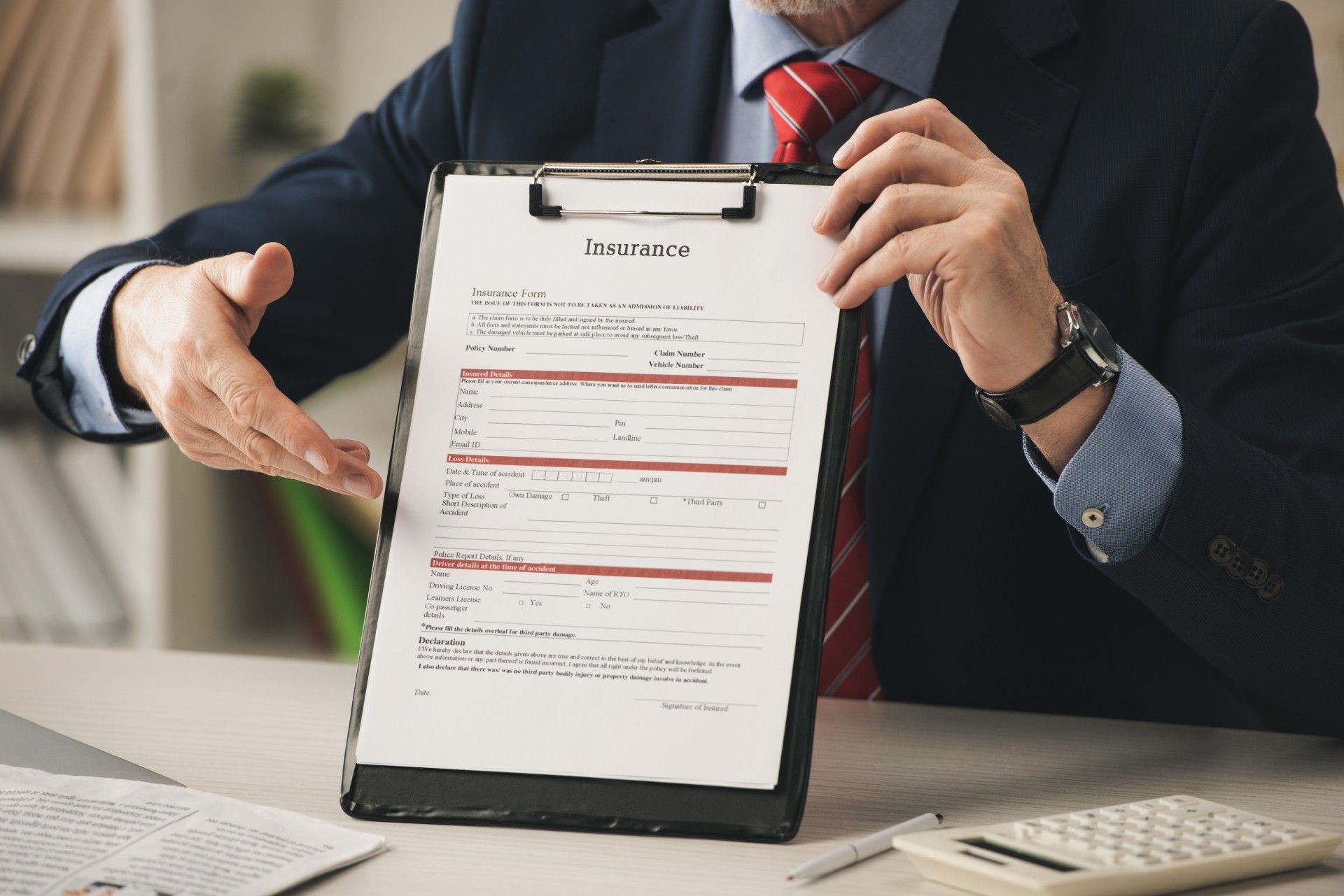 Man in a suit explains an insurance form to someone