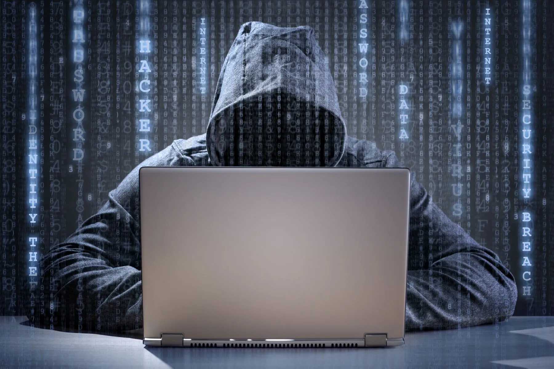 A hacker in a hoodie uses a laptop - oneplus data breach