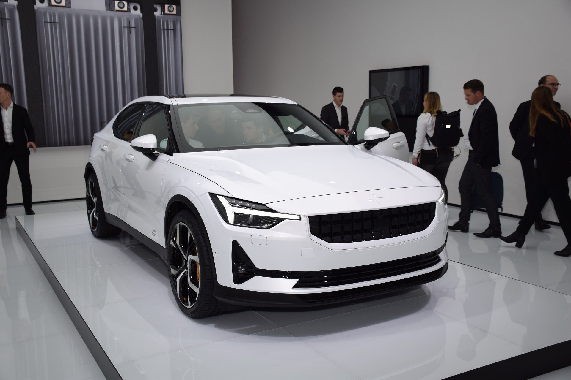 A white Polestar 2 at an auto show