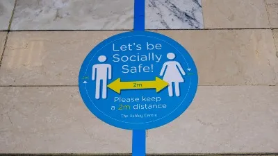 Stickers on the ground remind people to maintain social distancing - england lockdown