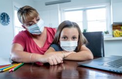 Mom and daughter home schooling regarding school closures amid COVID