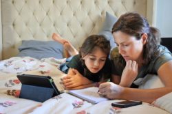 Mom helping daughter with hw regarding the legal action threatened over remote learning in the UK