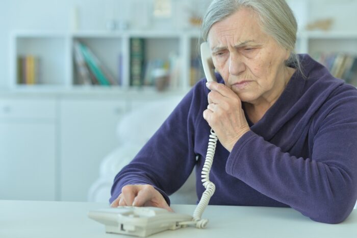 upset senior woman with phone