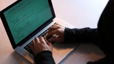 A hacker in a hoodie uses a laptop - loqbox