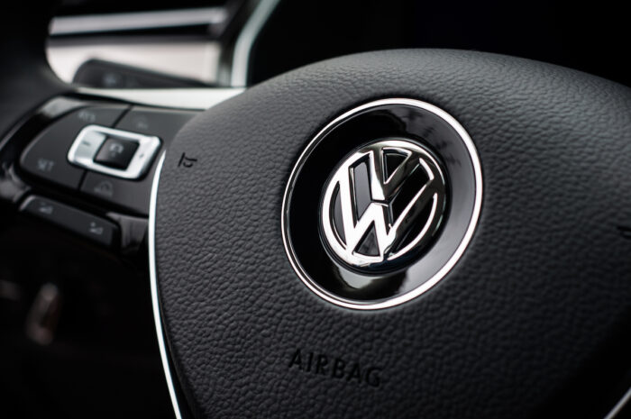 Photo of Volkswagen close up logo on steering wheel.