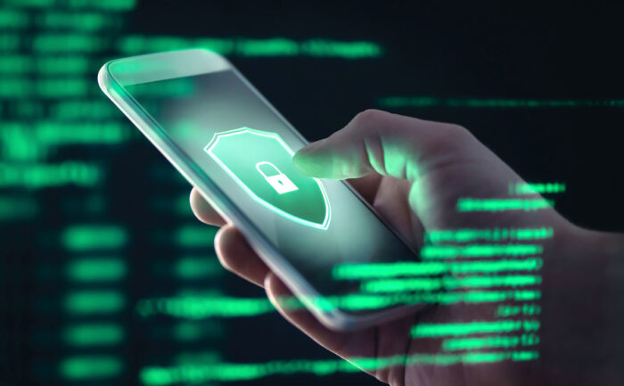 Close up of a hand holding a smartphone device with a lock displayed on the screen. Data privacy concept.