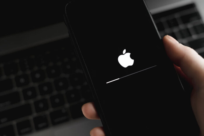 Close up of a hand holding an iPhone processing a software update.