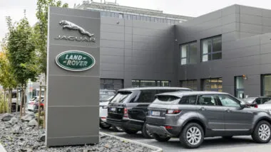 Jaguar Land Rover Sign outside dealership next to Land Rover SUVs