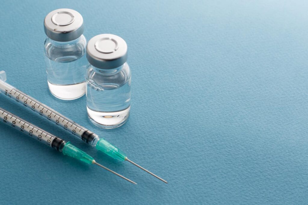 Close up of syringes and medicine bottles, representing the AstraZeneca vaccine.