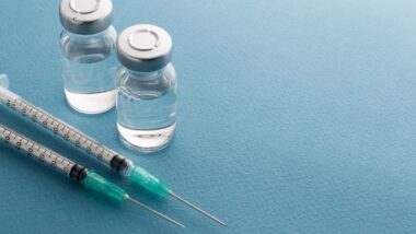 Close up of syringes and medicine bottles, representing the AstraZeneca vaccine.
