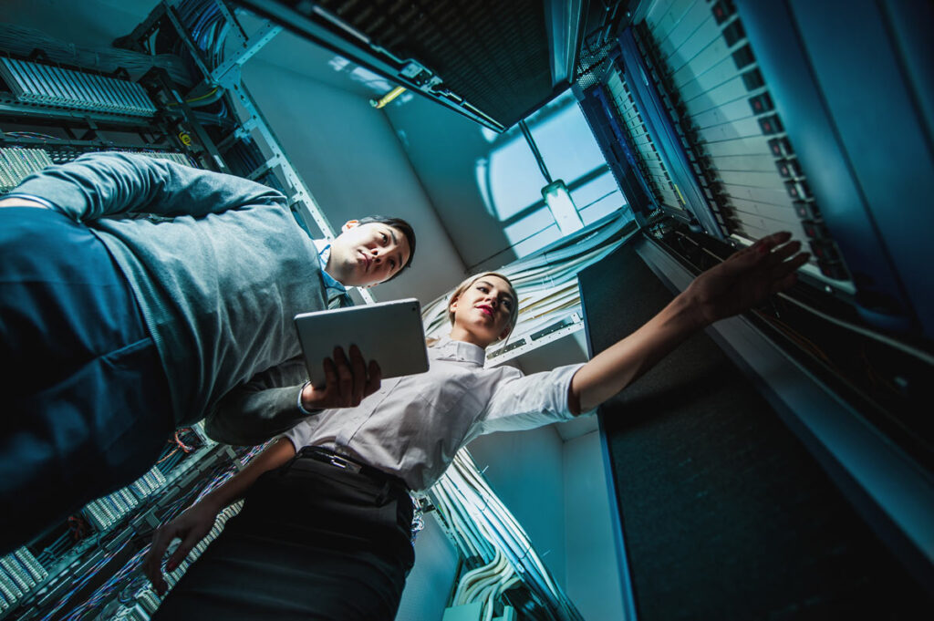 Engineers troubleshooting a problem in a server room, representing the health care data breach.
