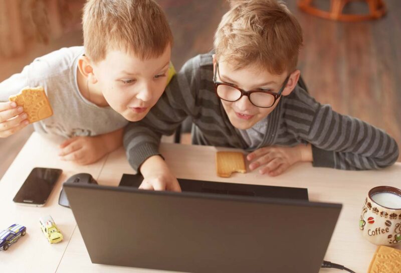 Two young boys using a laptop, representing the Online Safety Act.