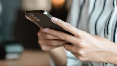 Close up of a womans hands using a smartphone, representing the journalist phone hack ruling.