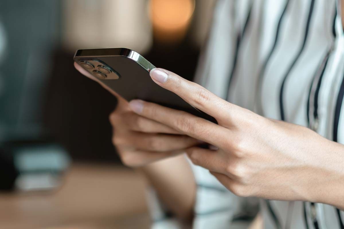 Close up of a womans hands using a smartphone, representing the journalist phone hack ruling.