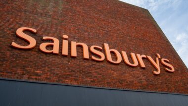 Large orange Sainsbury's brand sign on the side of a Sainsbury's supermarket