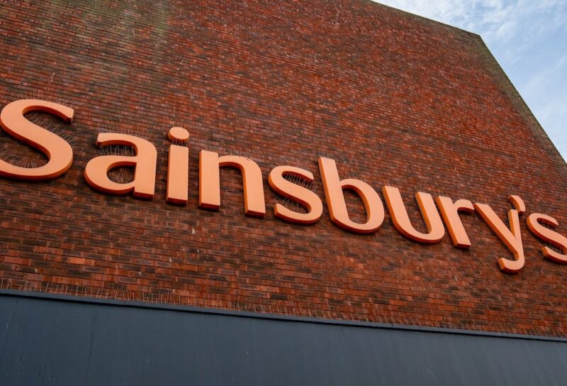 Large orange Sainsbury's brand sign on the side of a Sainsbury's supermarket